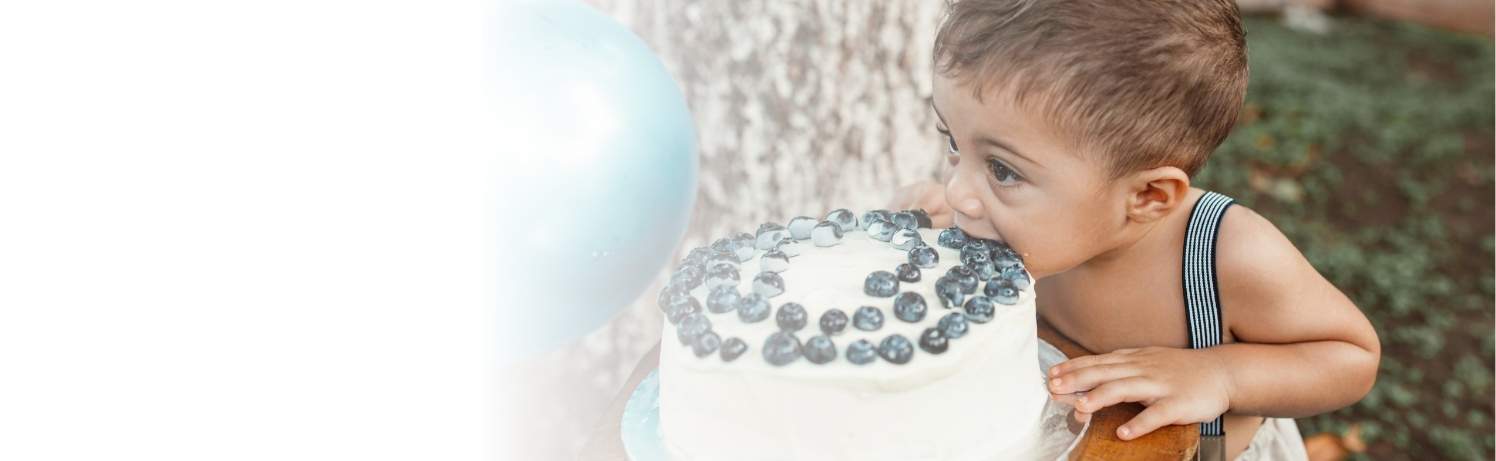 Picture of a toddler biting into a cake.