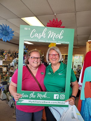 two women behind cash mob frame